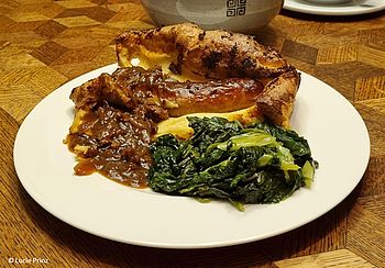 Teller mit Toad in the Hole, Soße und Blattspinat