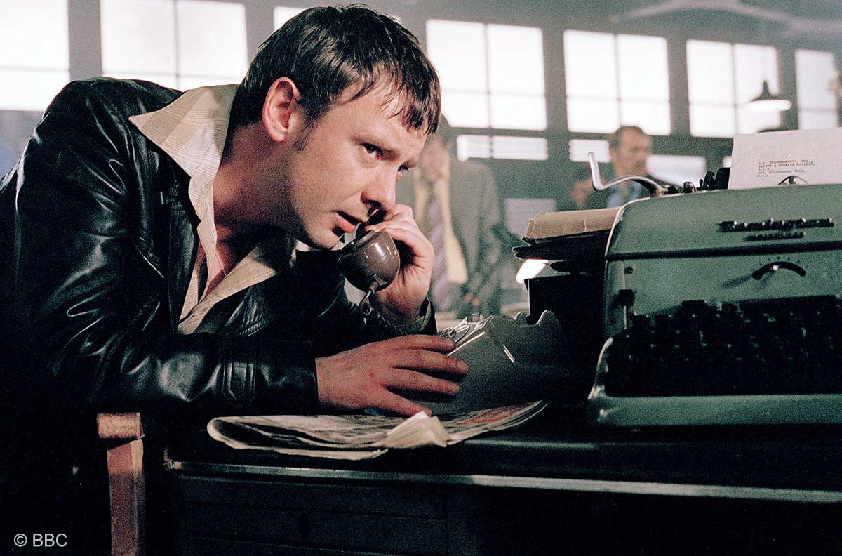 Ein Mann telefoniert in den 1970er-Jahren mit einem Wählscheiben-Telefon. Ein Mann telefoniert in den 1970er-Jahren mit einem Wählscheiben-Telefon.